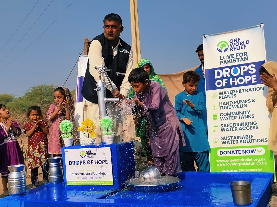 Child drinking clean water from an OWR hand pump in Pakistan